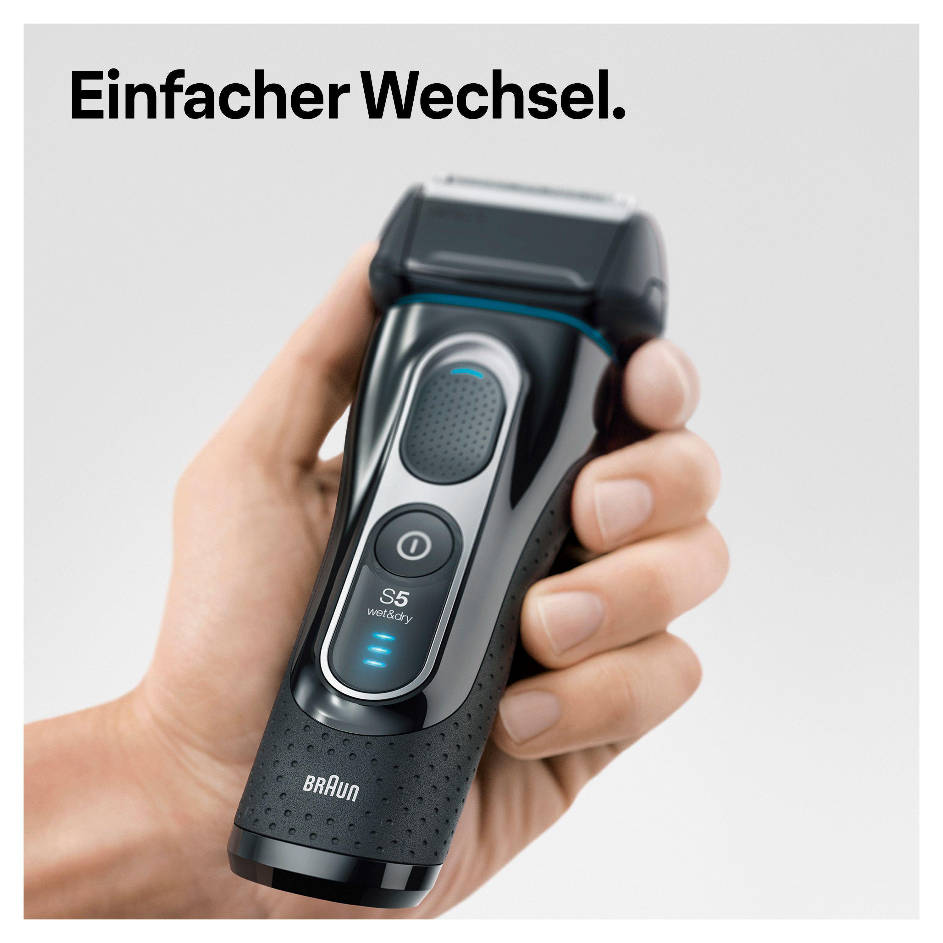 Eine Hand hält einen schwarzen Braun S5 Nass- und Trockenrasierer mit blauen Akzenten.