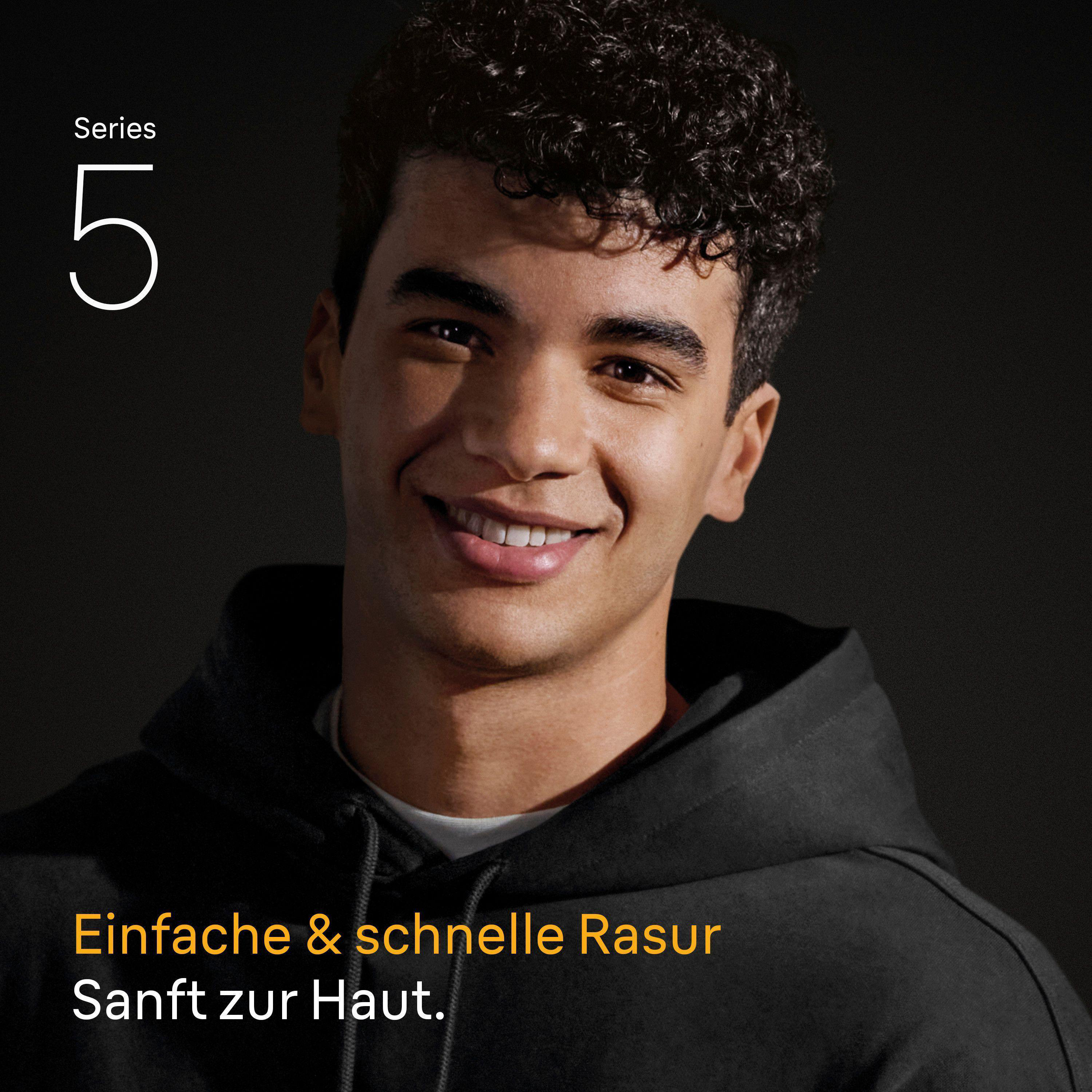 Junger Mann mit lockigem Haar lächelt, trägt schwarzen Hoodie. Text: Serie 5, Einfache Rasur.