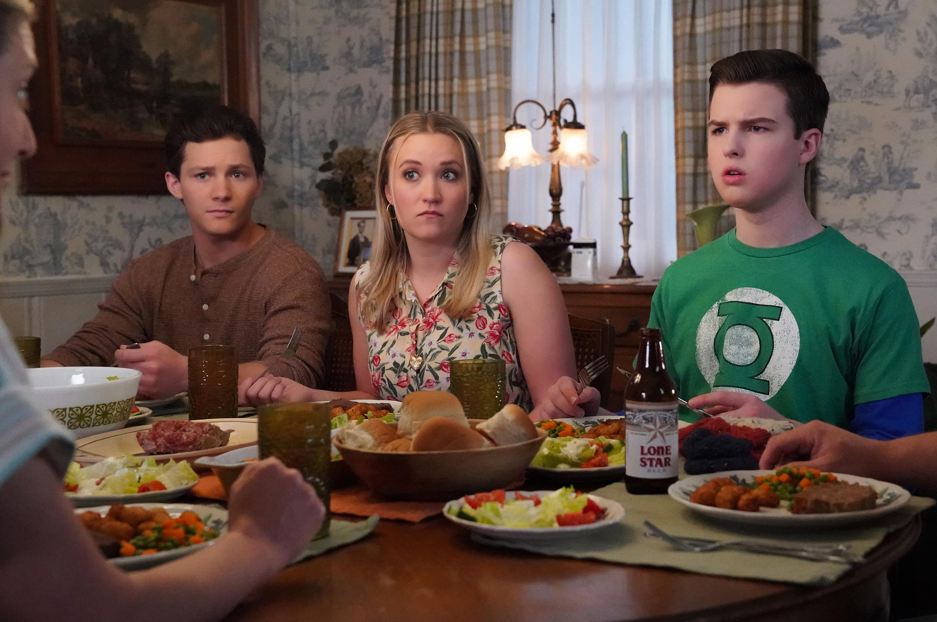 Eine Familie isst gemeinsam Abendessen. Auf dem Tisch stehen Speisen und Getränke.