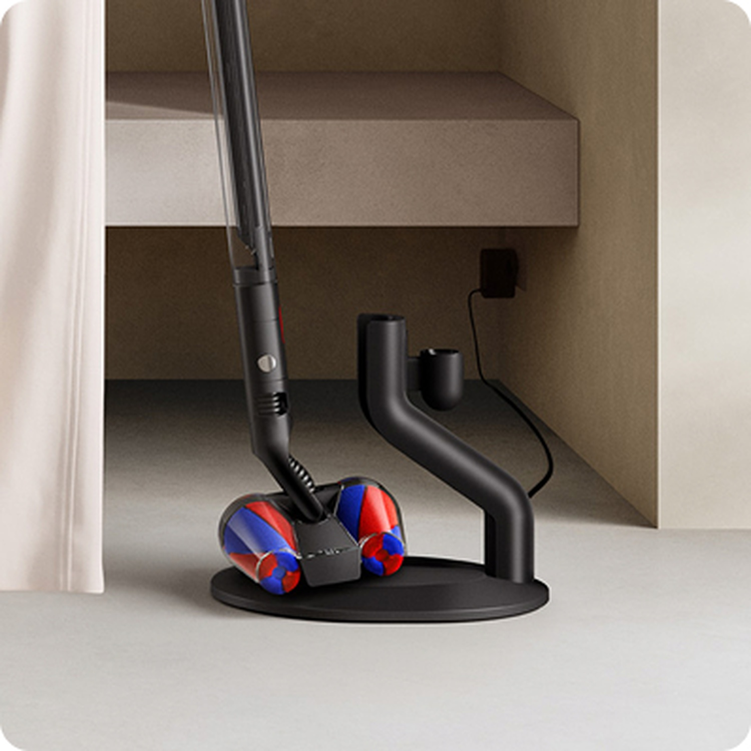 Un aspirateur noir avec des rouleaux rouges et bleus est sur une station de charge.