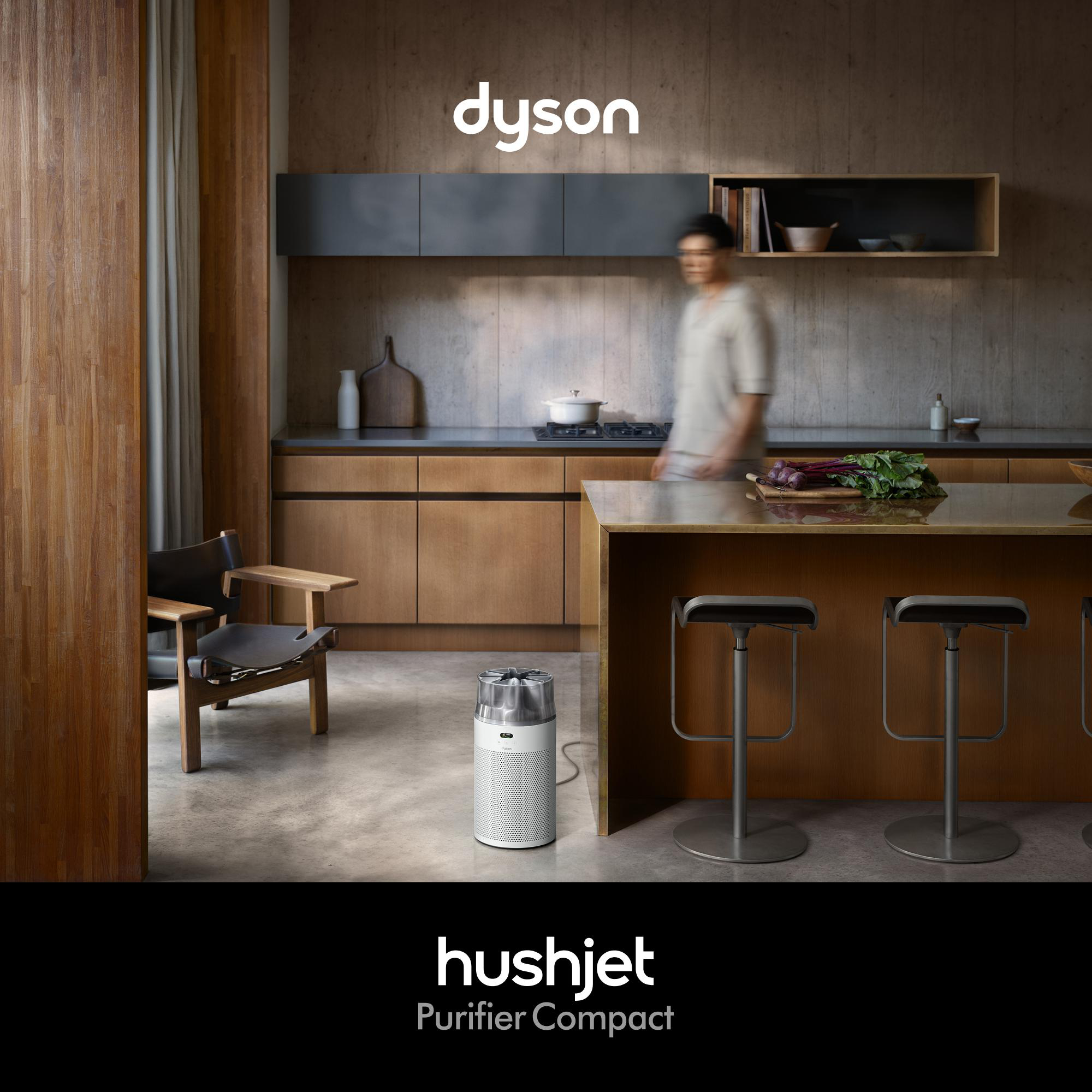 Ein Mann geht an einem Dyson Luftreiniger in einer modernen Küche vorbei.