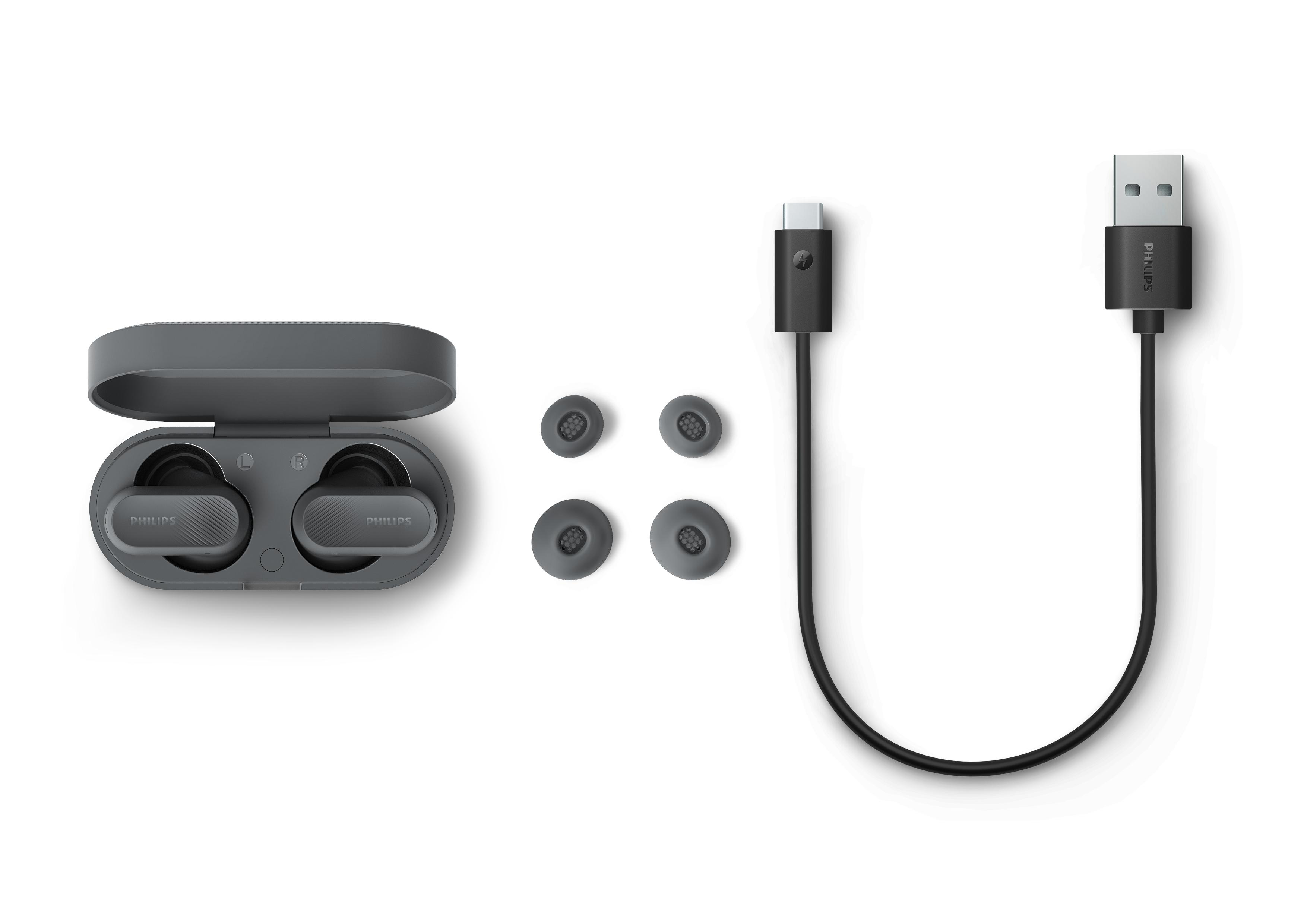 Graue Philips Ohrhörer mit Ladecase, Ersatzaufsätzen und USB-C-Kabel.