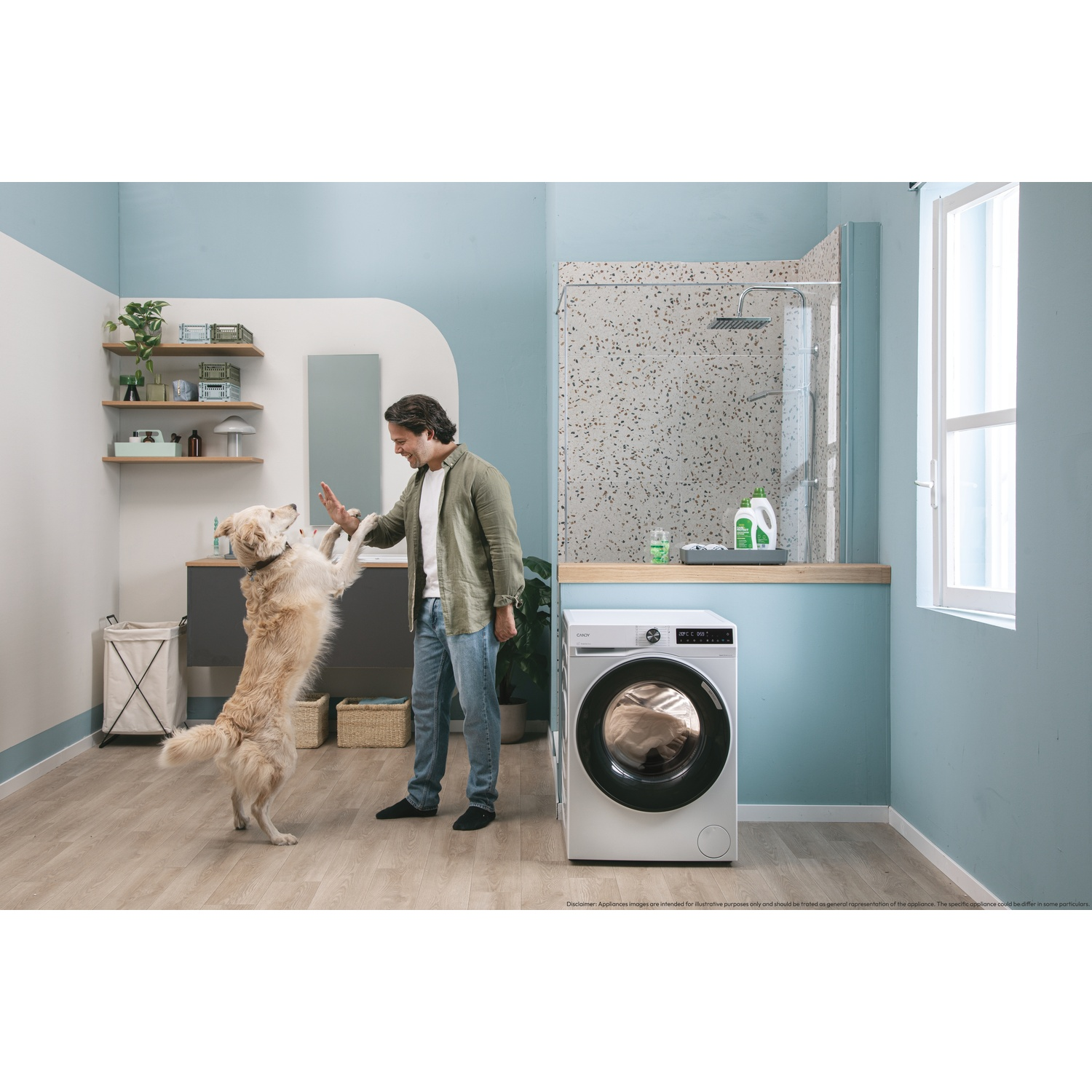Un uomo gioca con un Golden Retriever in un bagno con lavatrice e doccia.