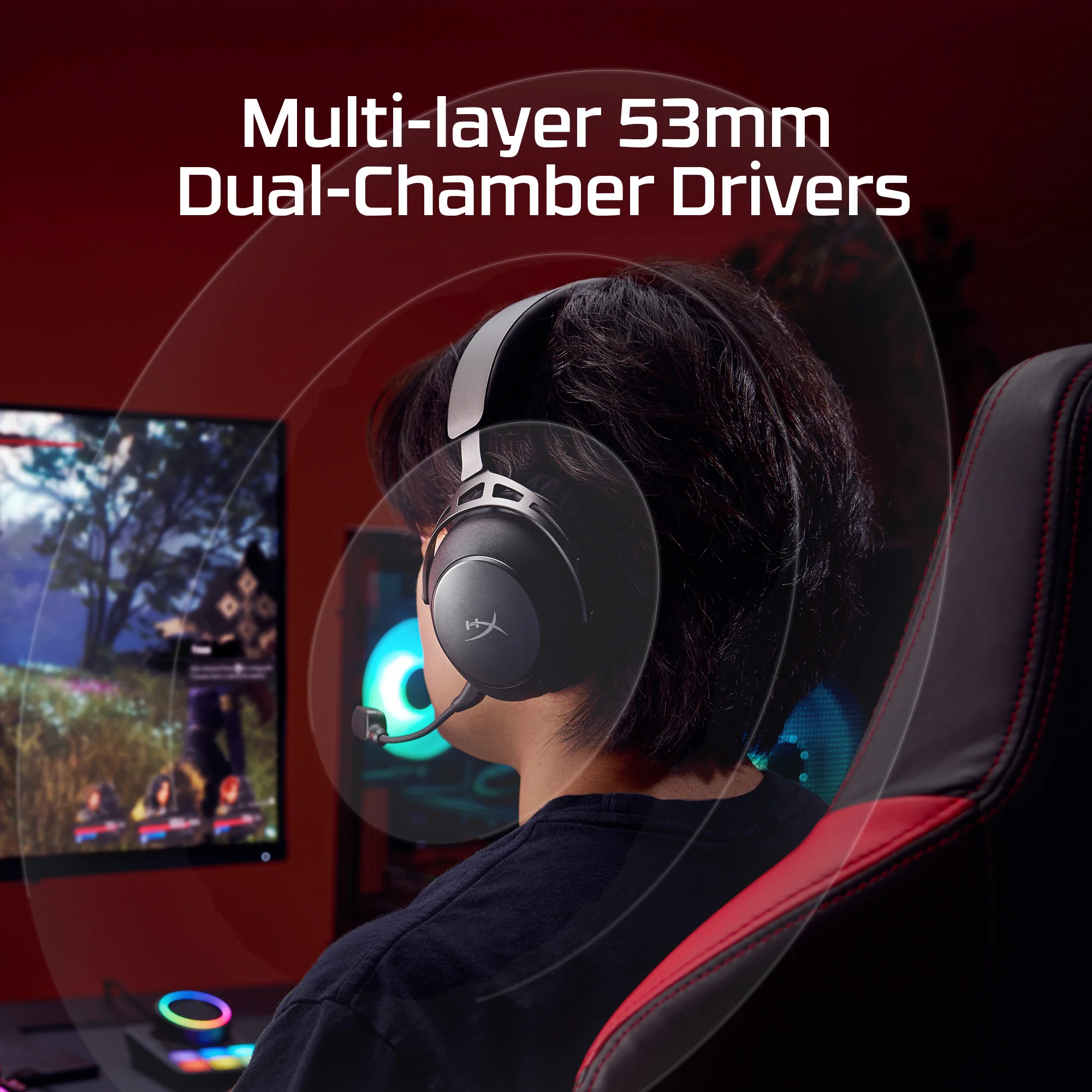 Person mit Kopfhörern spielt Videospiel vor dem Monitor in einem Gaming-Stuhl.