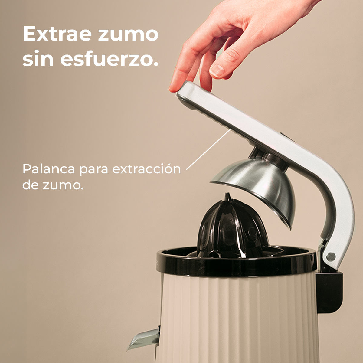 Una mano presiona la palanca de un exprimidor con parte superior plateada y cono negro.