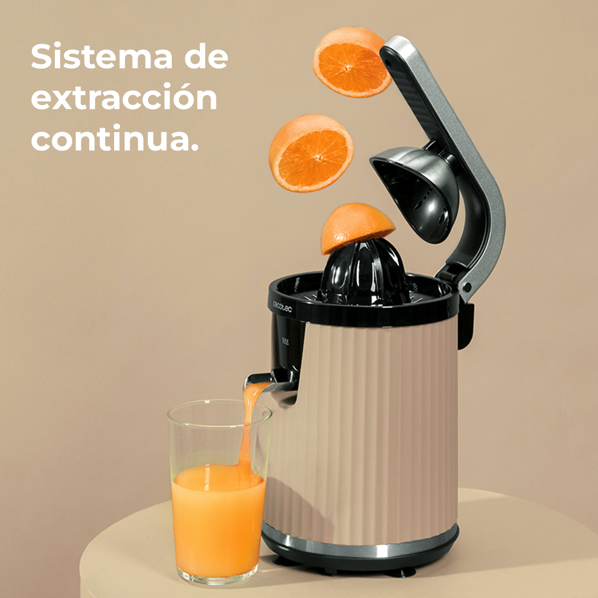 Un exprimidor extrae naranjas mientras el jugo fluye hacia un vaso.