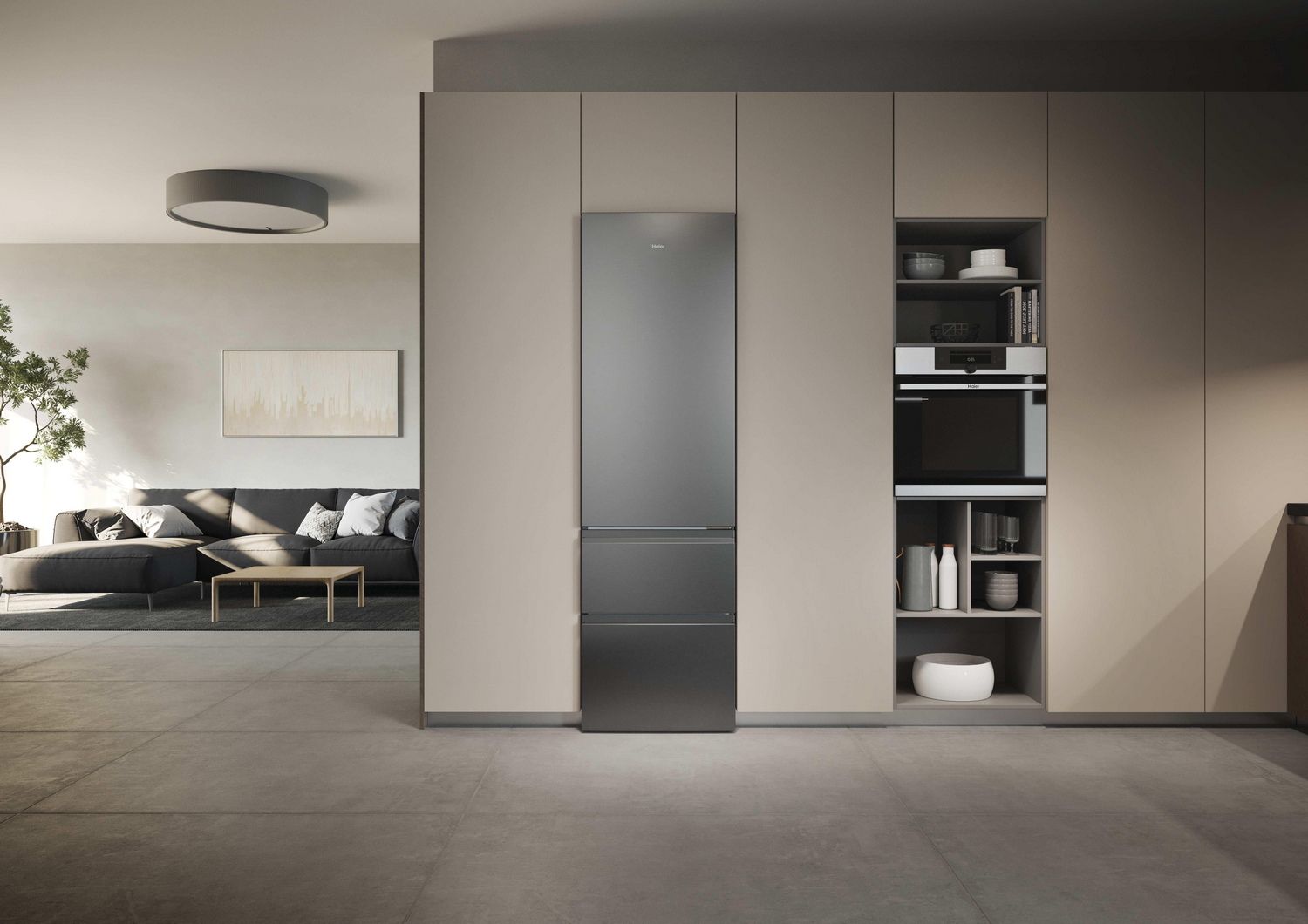 Un área de cocina moderna con refrigerador, horno empotrado y sofá en la sala.