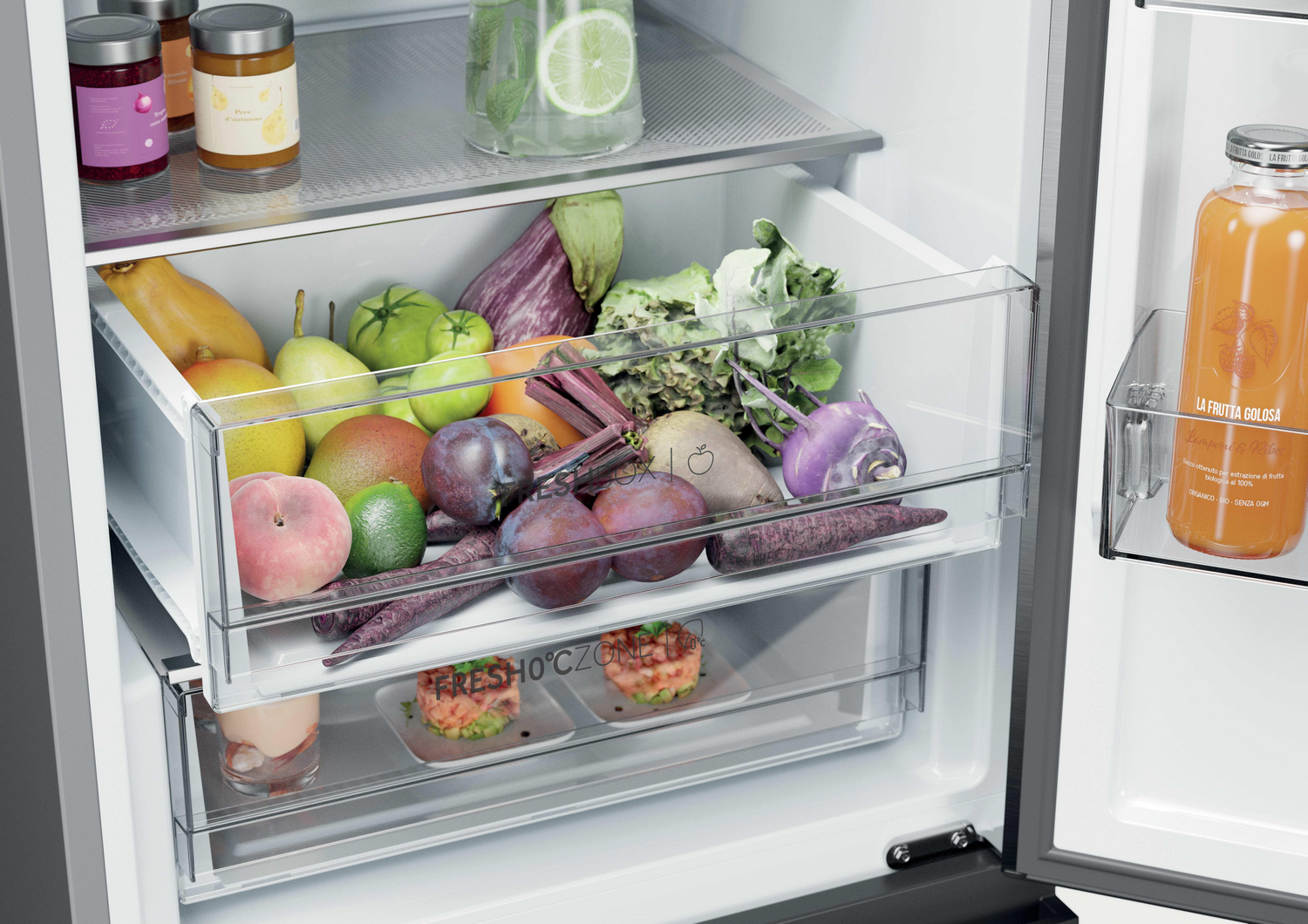 Un refrigerador con frutas y verduras en cajones, botellas en un compartimento.