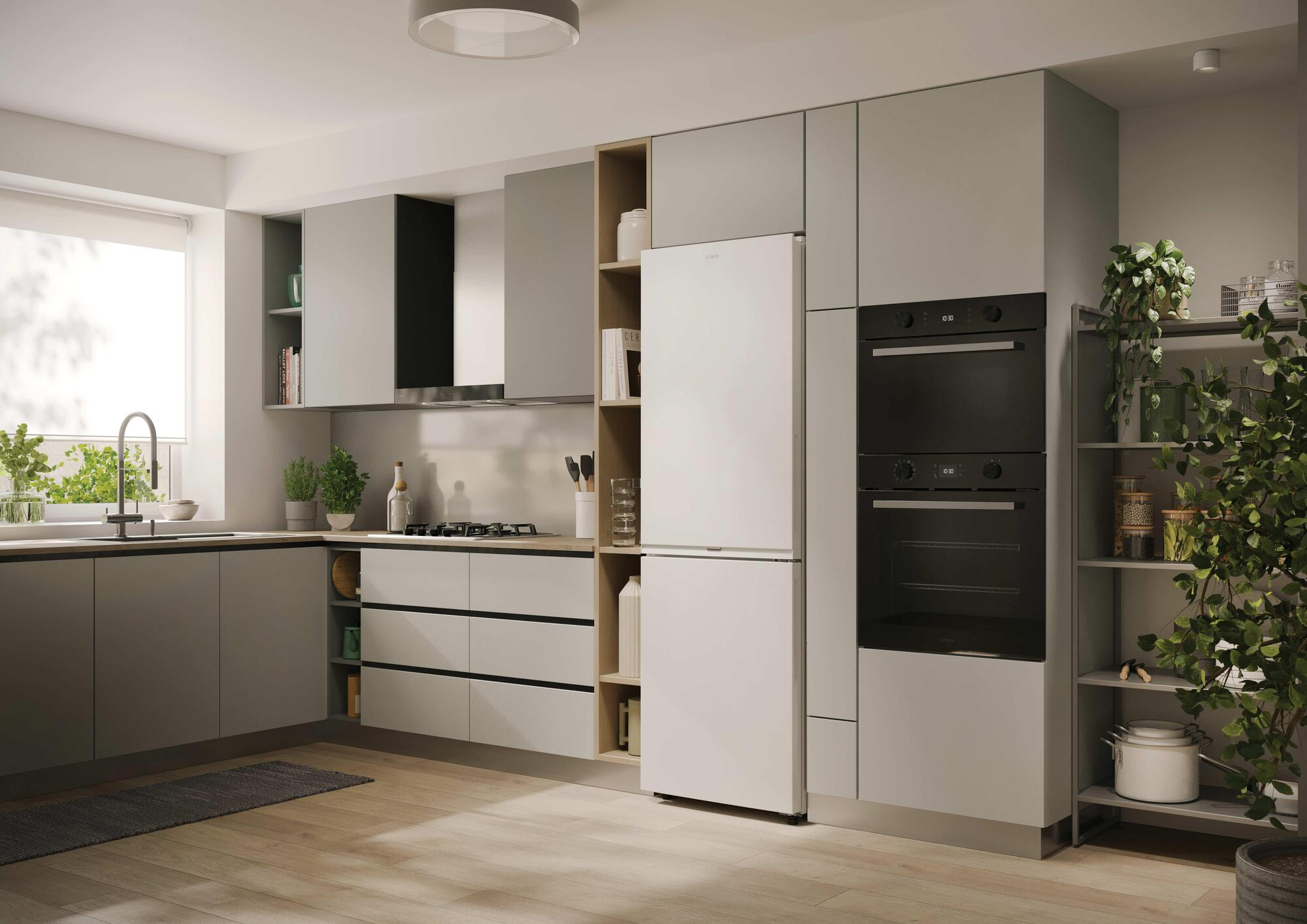 Cocina moderna gris con electrodomésticos blancos, suelos de madera y plantas.