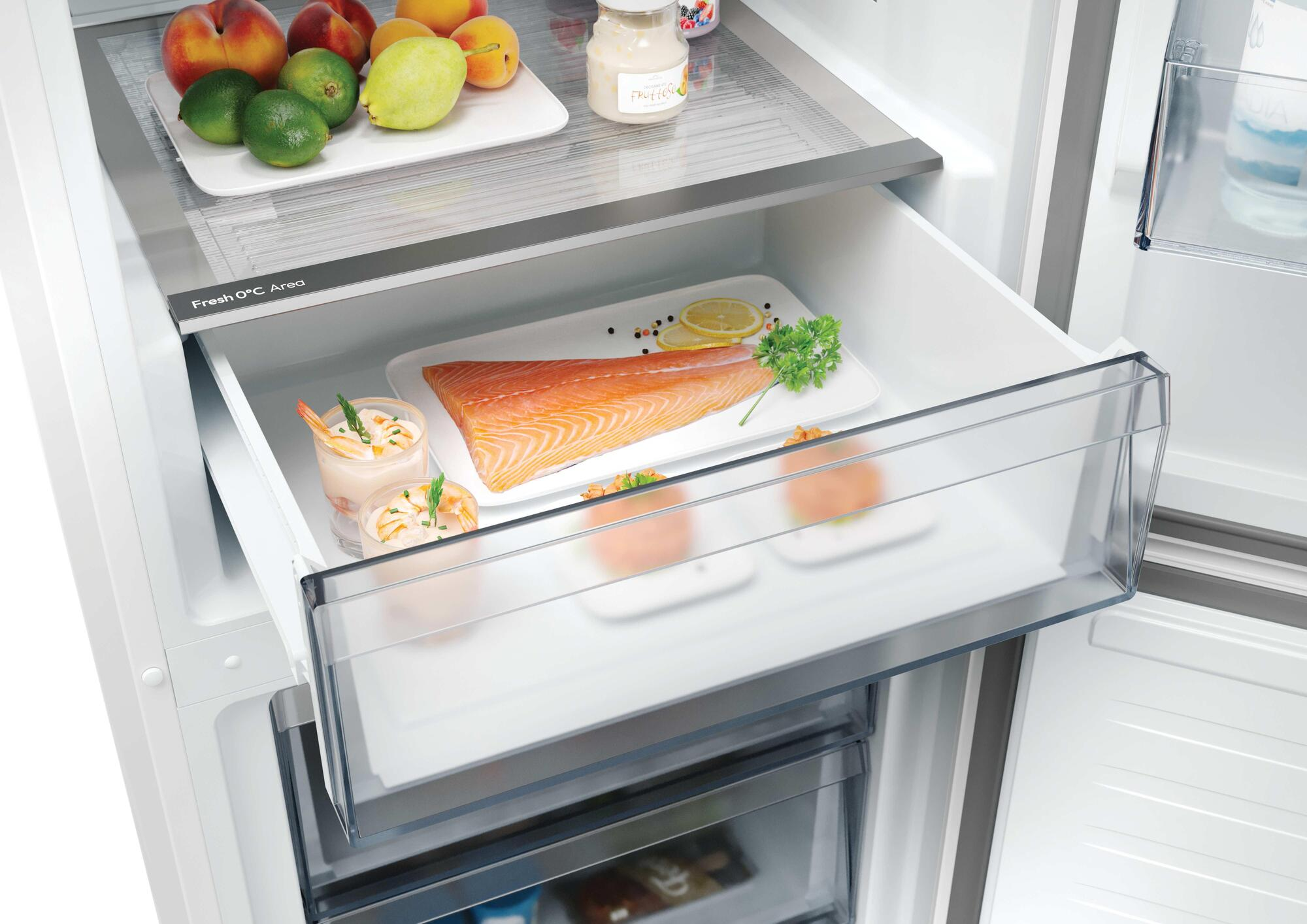 Cajón de refrigerador con filete de salmón, camarones y frutas.