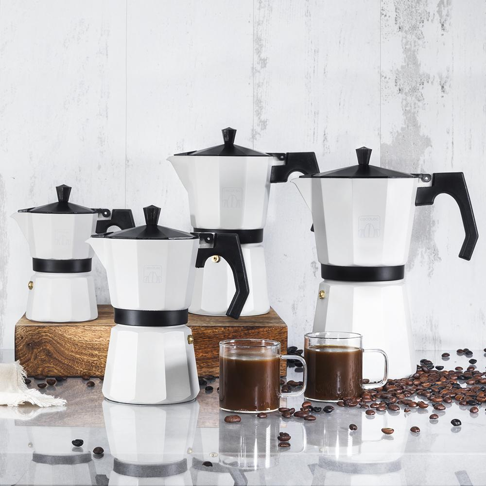 Cinco cafeteras moka blancas con tapas y asas negras, dos tazas de café.