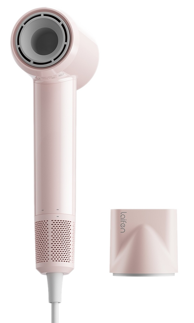 Różowa suszarka do włosów z odpinaną dyszą leży na czarnym tle.