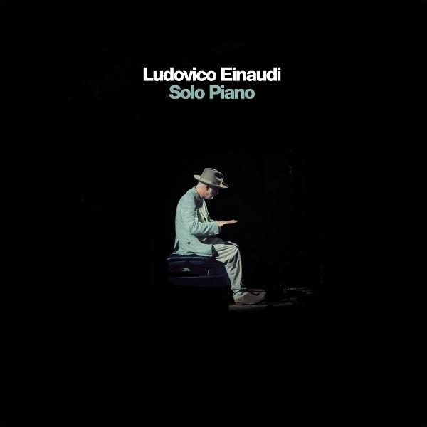 Mann in Hut spielt Klavier im Dunkeln. Text: Ludovico Einaudi Solo Piano.