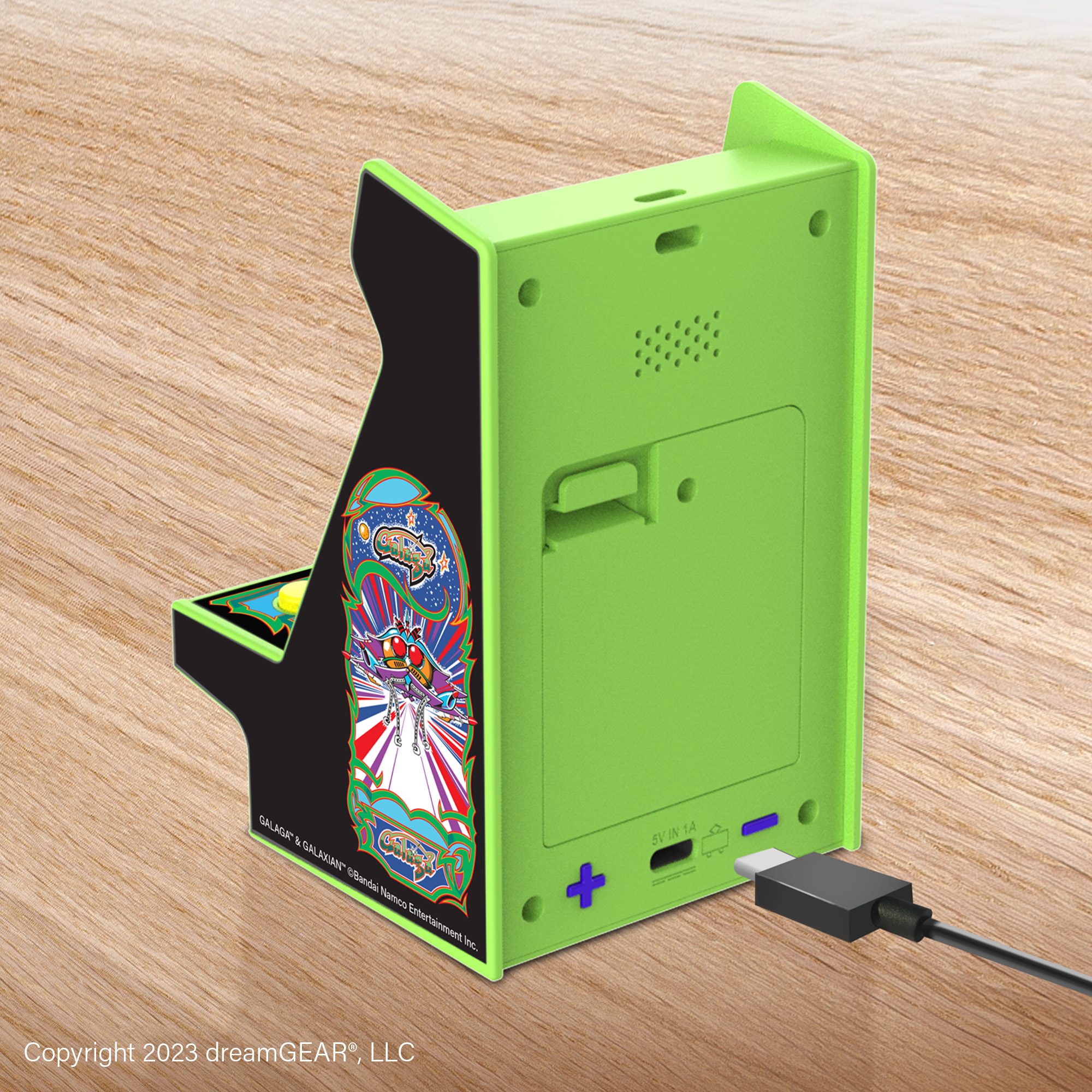 Galaga grafikalı küçük yeşil atari salonu kabini, USB ile şarj ediliyor.