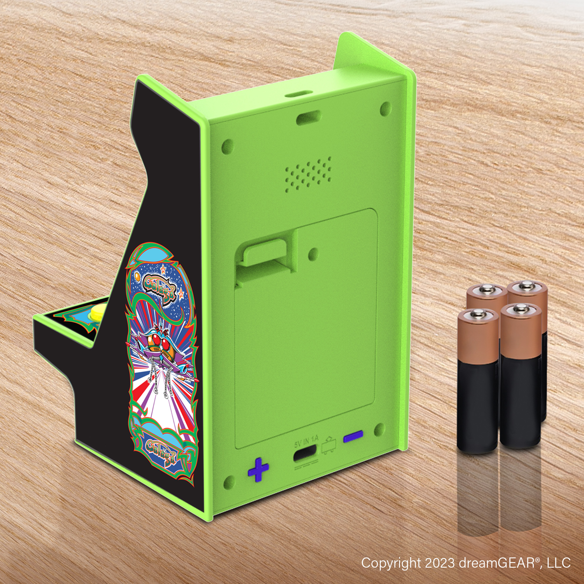 Uzay grafikalı neon yeşili mini atari oyunu, ahşap üzerinde dört AA pille birlikte.