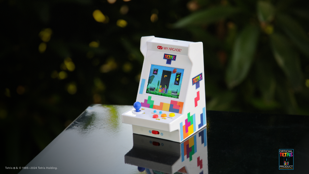 Joystick ve renkli düğmelere sahip minyatür Tetris atari makinesi, yansıtıcı yüzeyde.