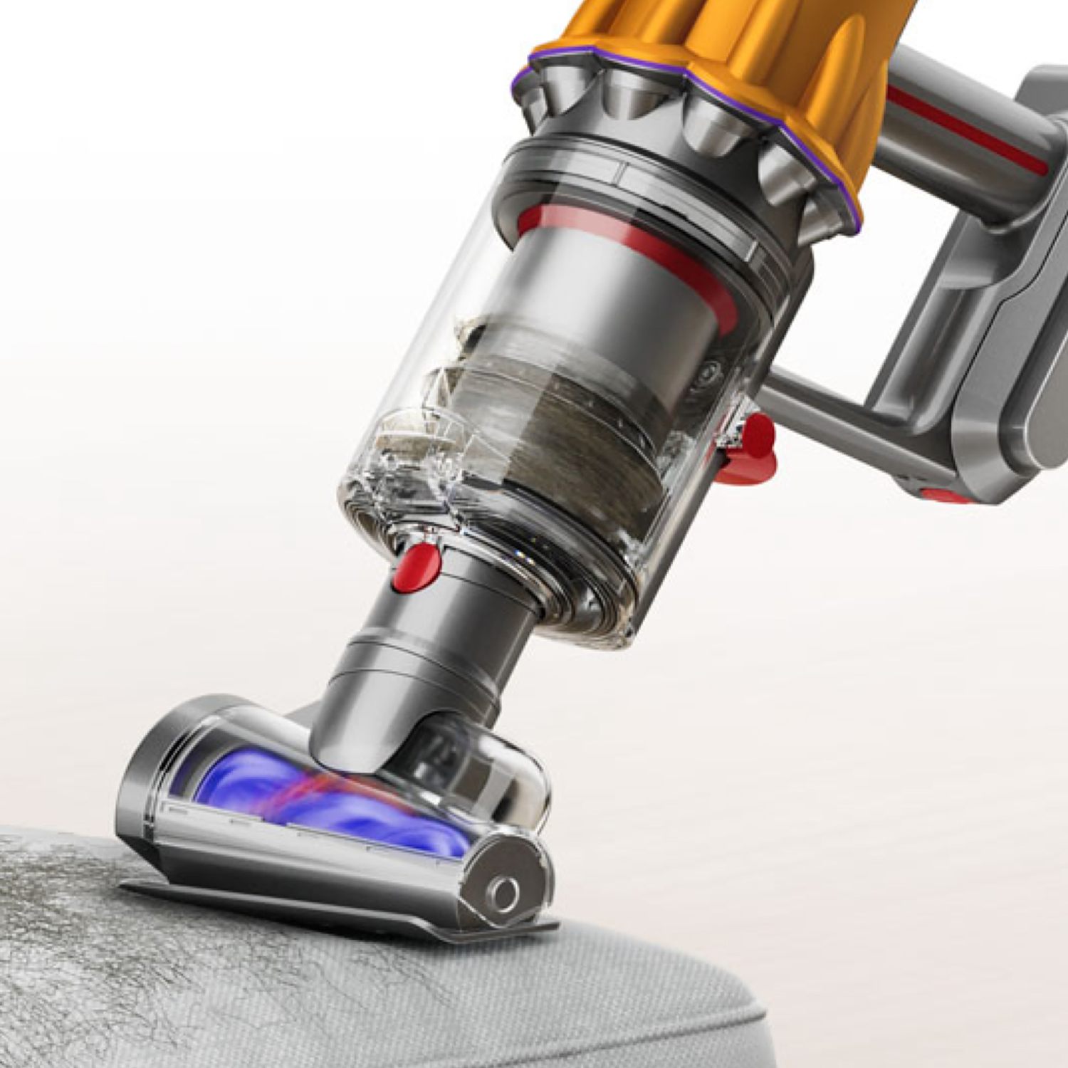 A yellow Dyson vacuum head cleans grey fabric. Blue suction shown.