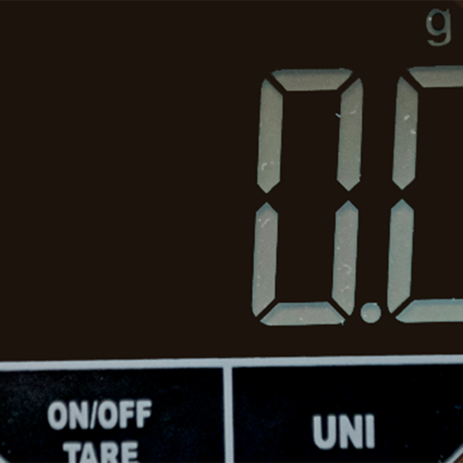 Bilancia digitale mostra 0.0g. Pulsanti: ON/OFF TARE, UNI.