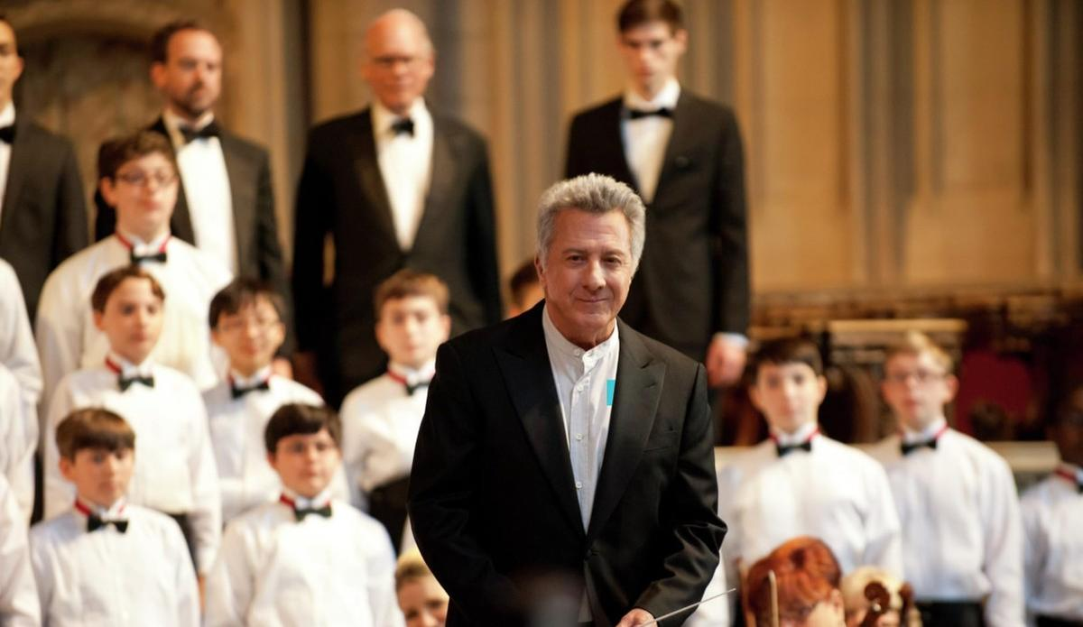 Dustin Hoffman steht vor einem Chor von Jungen in Gala-Kleidung.