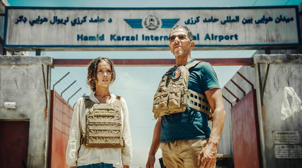Mann und Frau mit Schutzwesten vor dem Flughafen Kabul, Afghanistan.