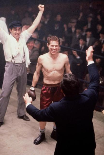 Boxer im Ring, sein Trainer hebt die Hand. Menge jubelt.