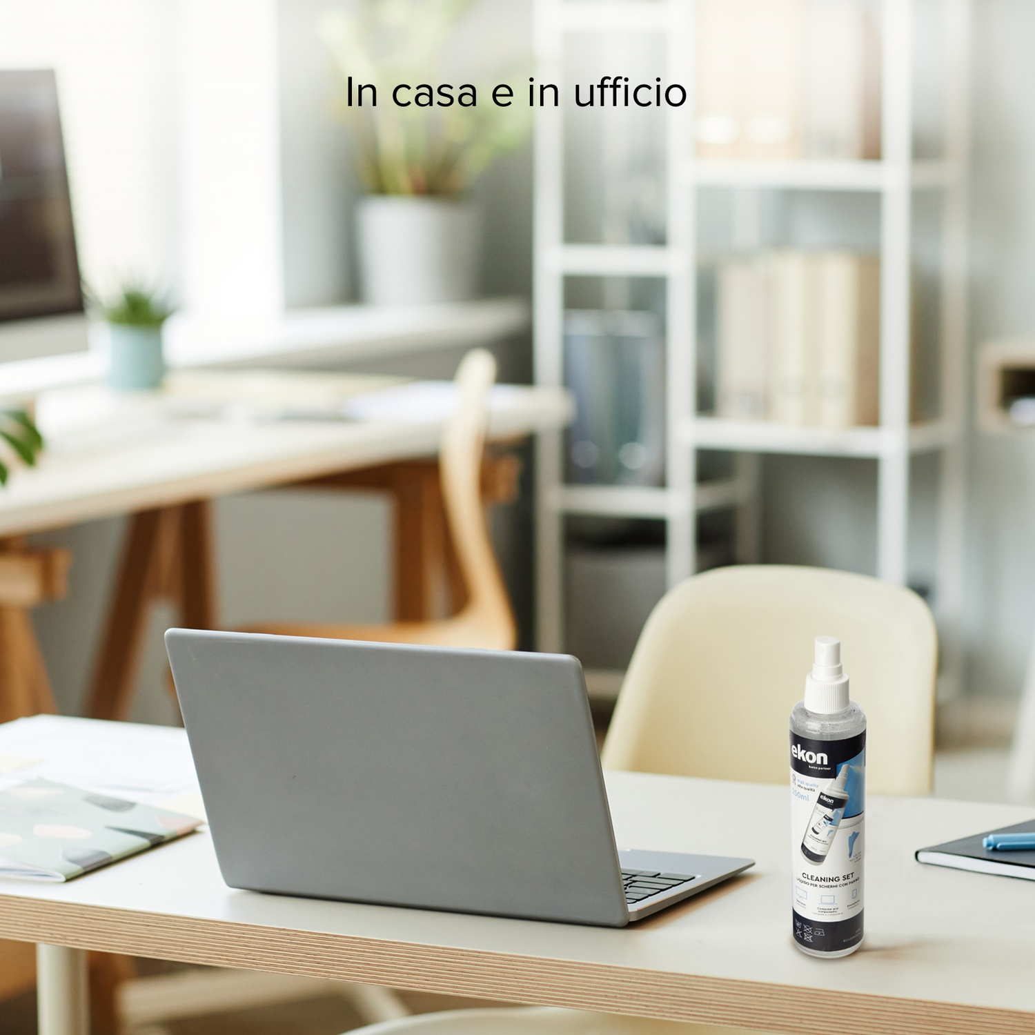 Un laptop e una bottiglia spray su una scrivania d'ufficio.