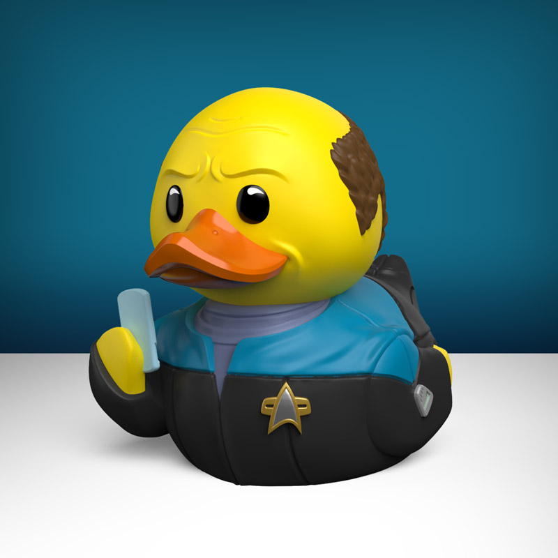 Egy sárga gumikacsa Star Trek-egyenruhában kék tárgyat tart.