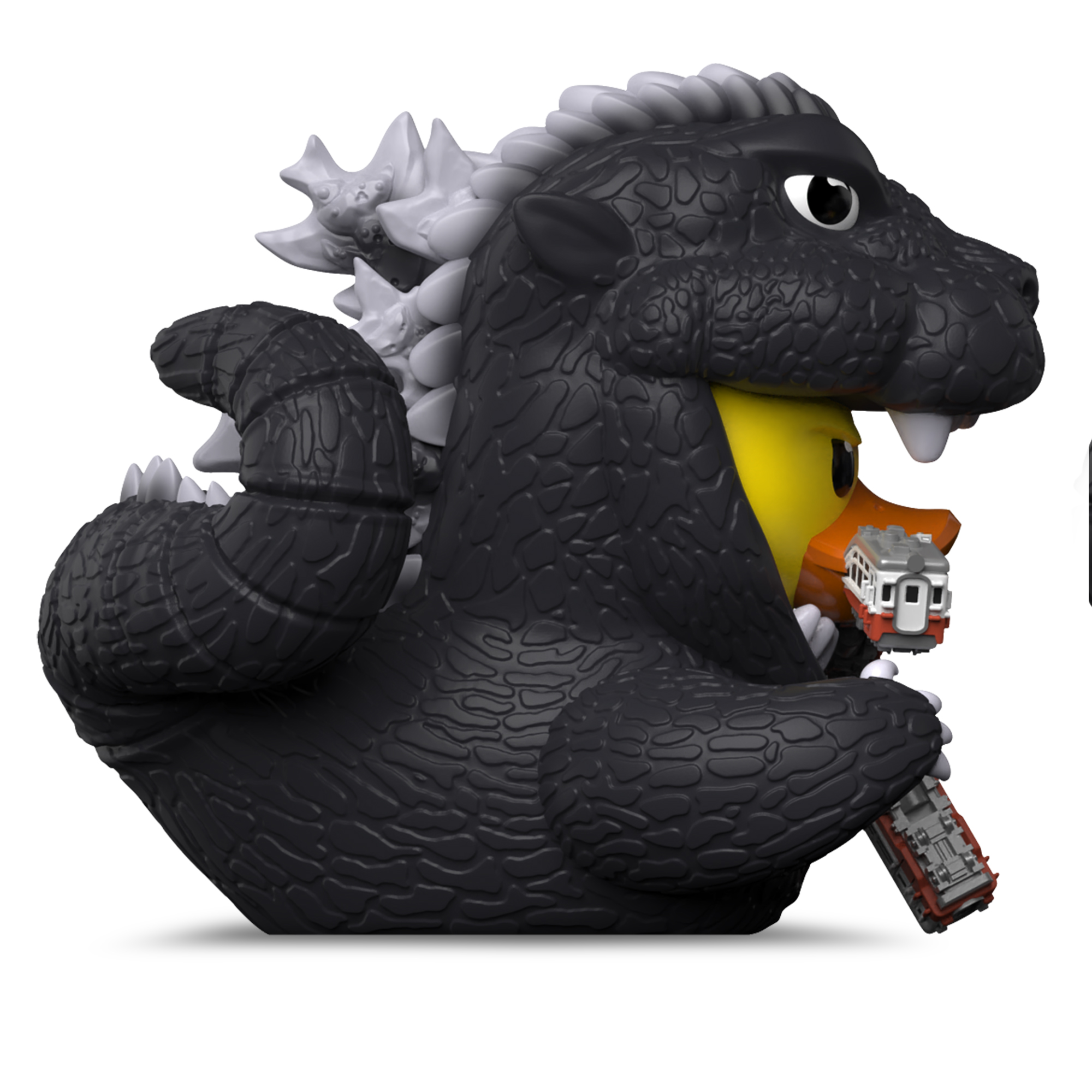 Godzilla figura sárga kacsát tart piros vonatokkal a szájában és kezében.