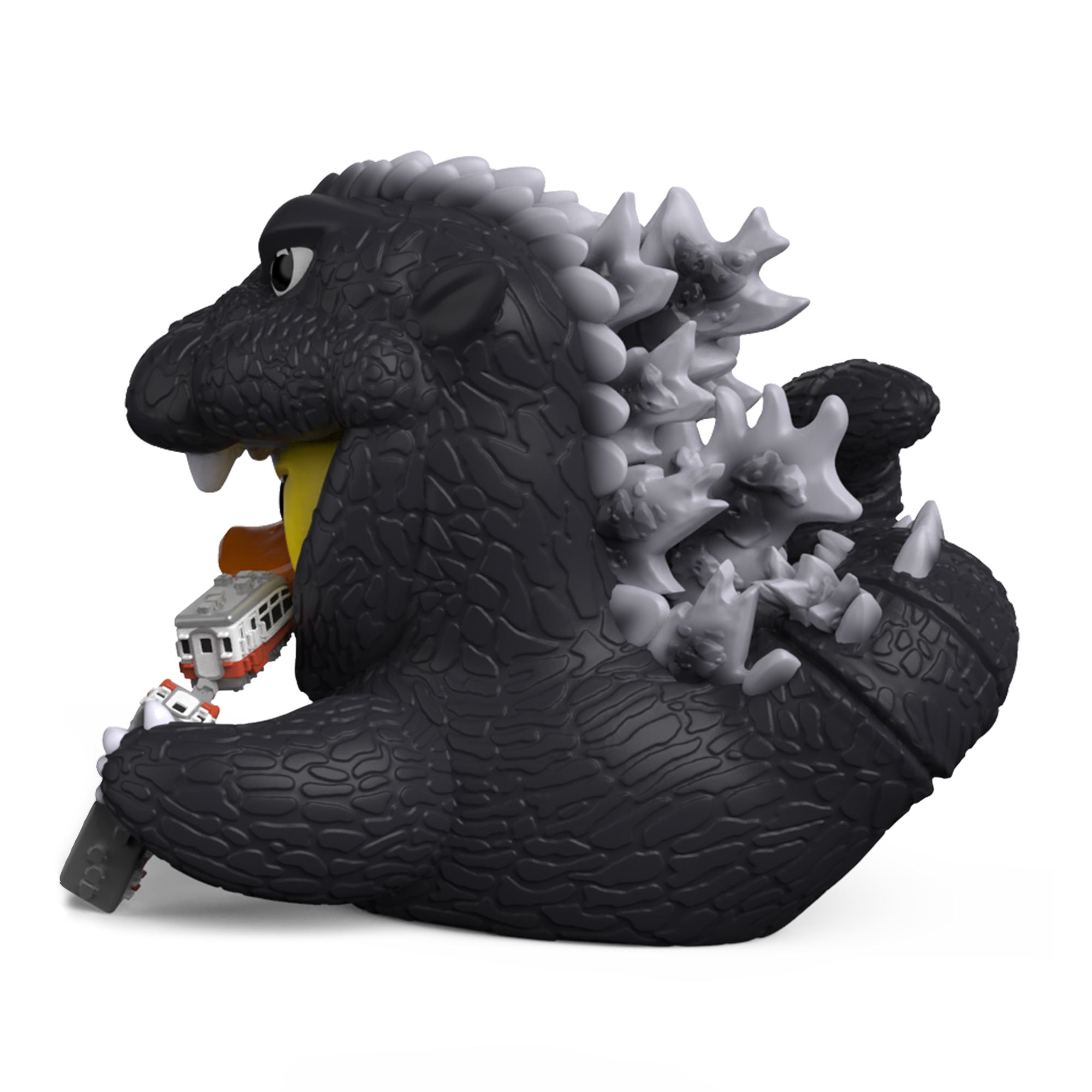 Egy Godzilla játék a szájában tart egy vonatot.