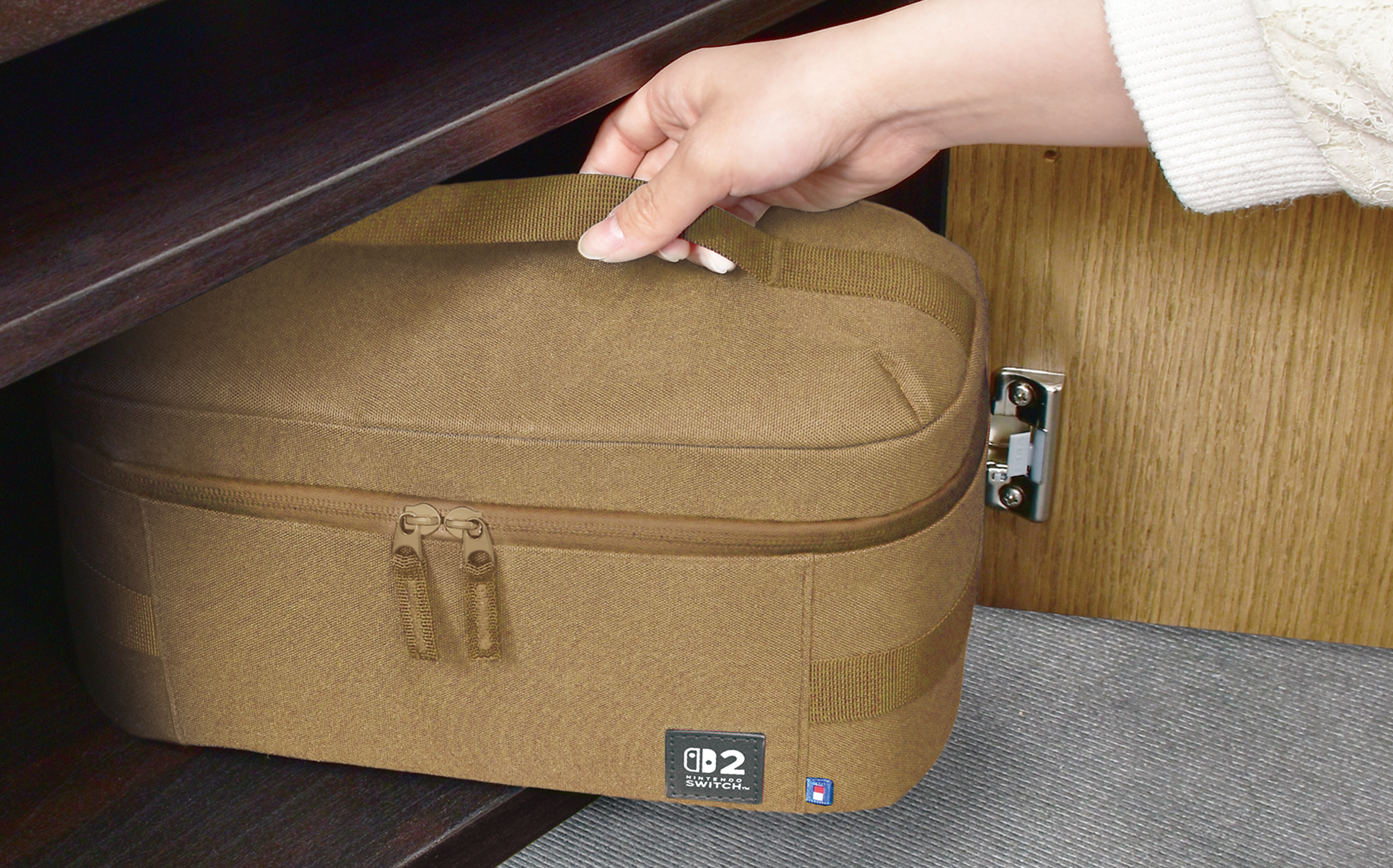 Eine Hand greift nach einer braunen Tasche mit Nintendo Switch-Logo in einem Schrank.