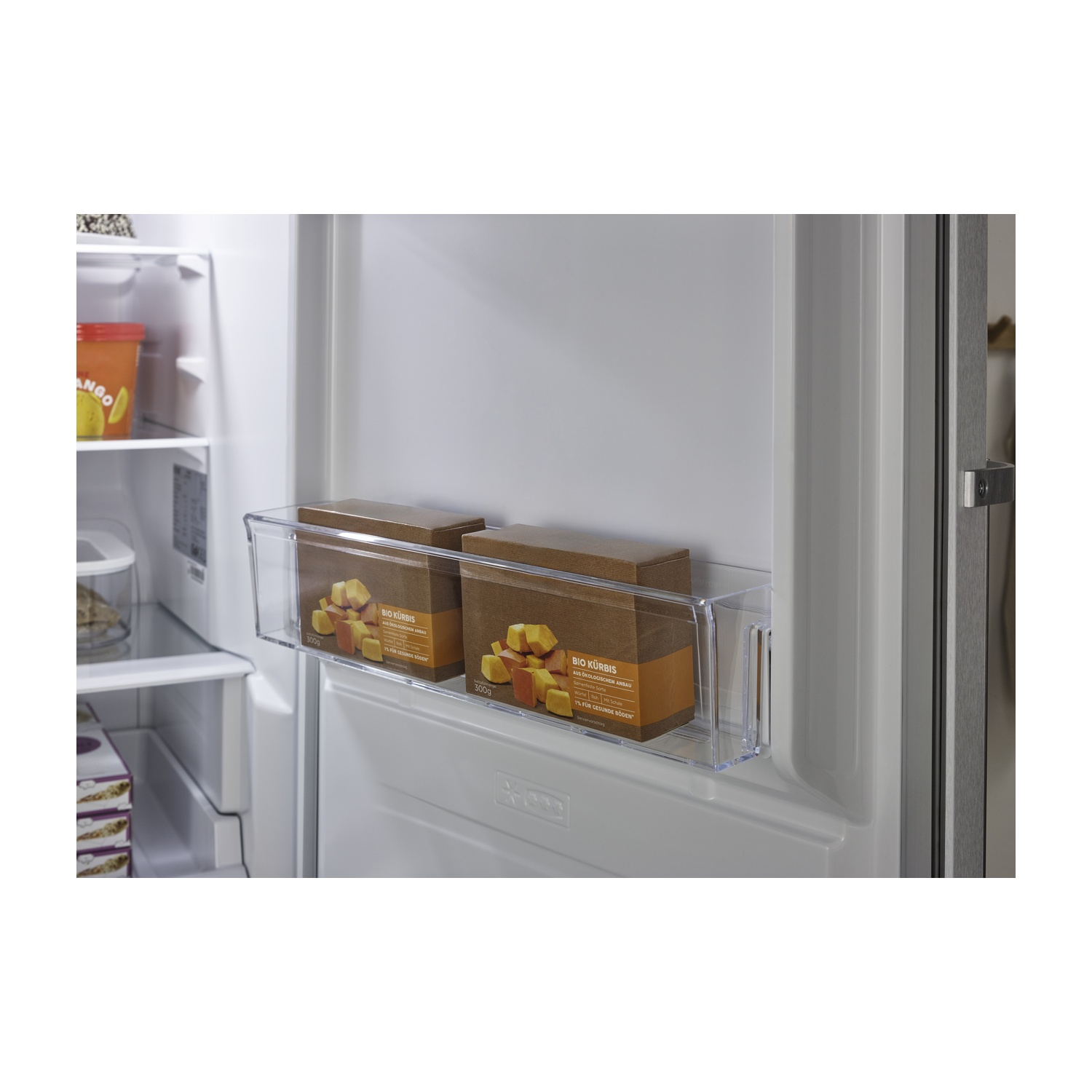 Due scatole marroni con zucca nel frigorifero, accanto a una tazza gialla.
