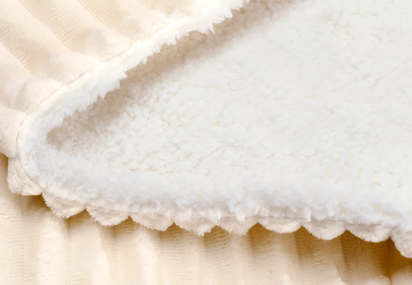 Coperta color crema con texture a coste e bordo morbido e soffice.