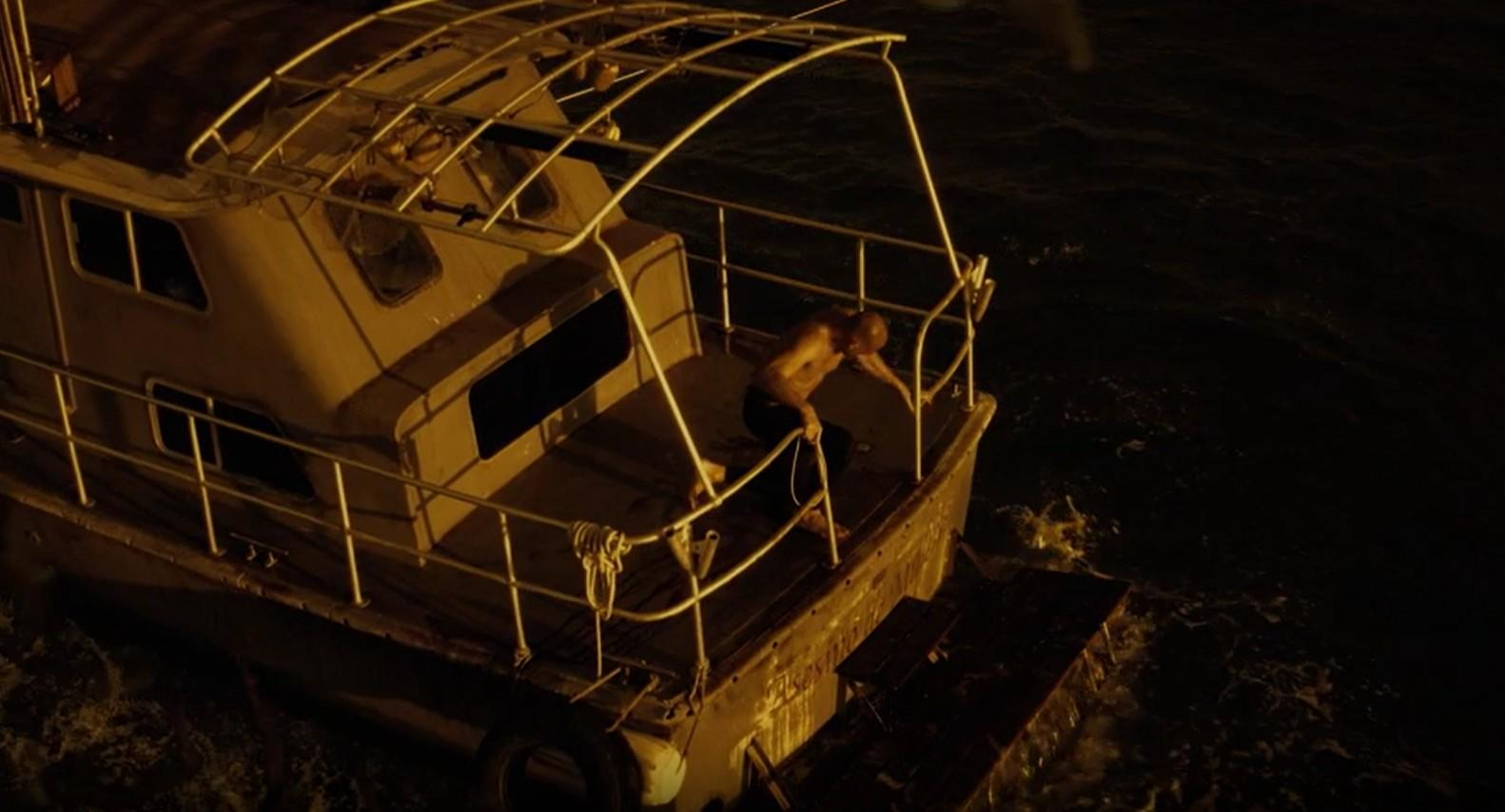 Ein Mann auf einem Boot im dunklen Wasser.