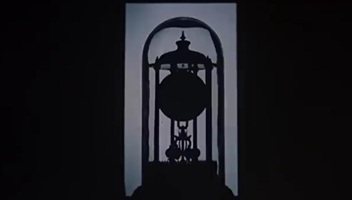 Silhouette einer antiken Pendeluhr unter einer Kuppel auf dunklem Hintergrund.