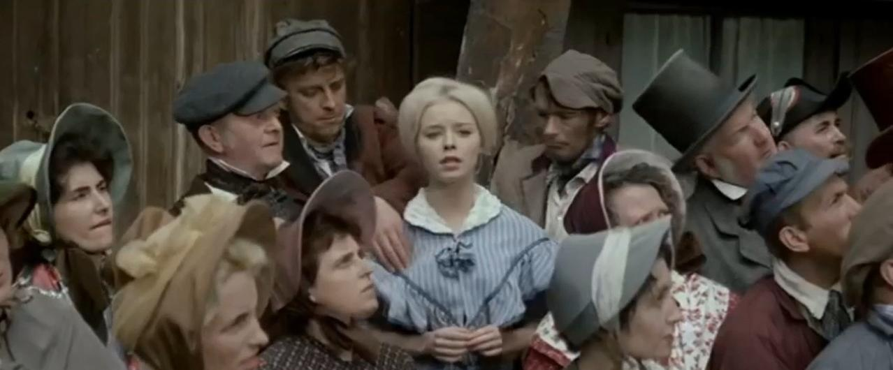 Eine Gruppe von Menschen in historischer Kleidung steht dicht gedrängt.