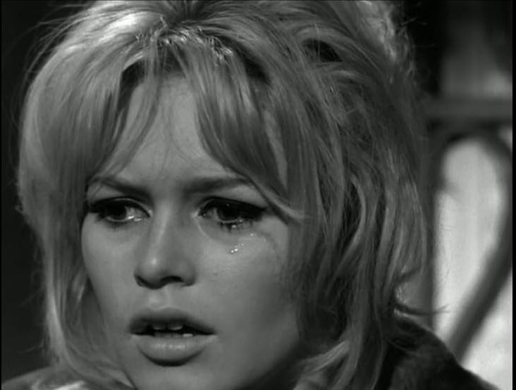 Nahaufnahme einer weinenden Frau mit blonden Haaren und dramatischem Make-up.