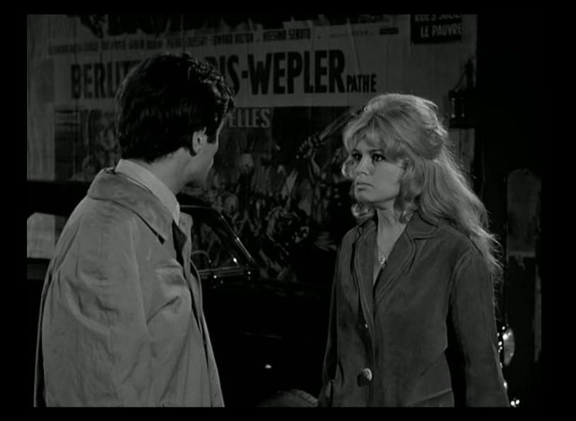Ein Mann und eine Frau stehen vor Filmplakaten. Sie unterhalten sich.