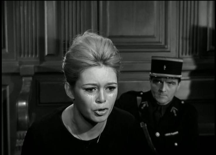 Eine weinende Frau im Vordergrund, ein Mann in Uniform im Hintergrund.