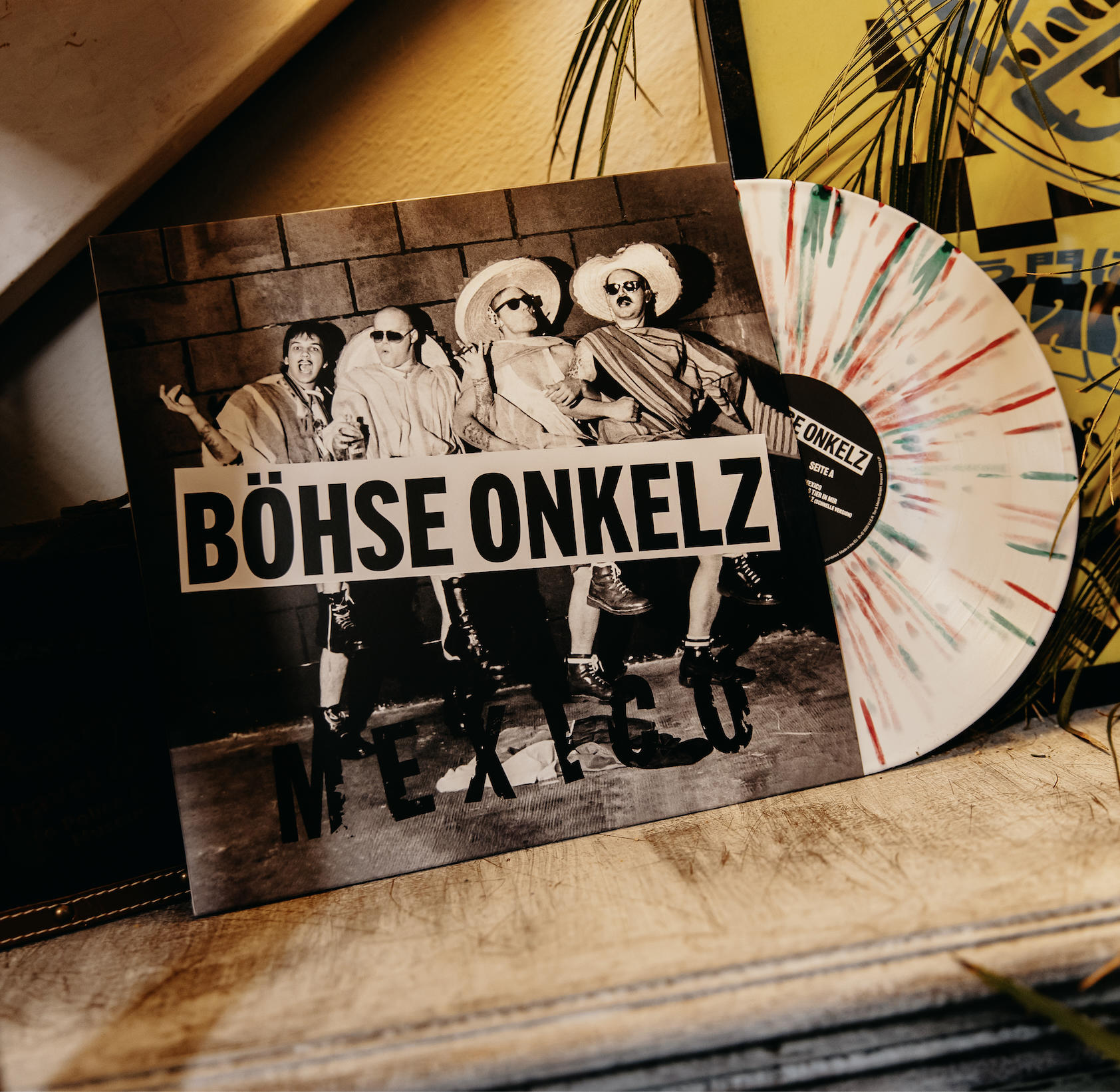 Böse Onkelz Vinyl-Schallplatte mit Bandfoto und buntem Splatter-Design.