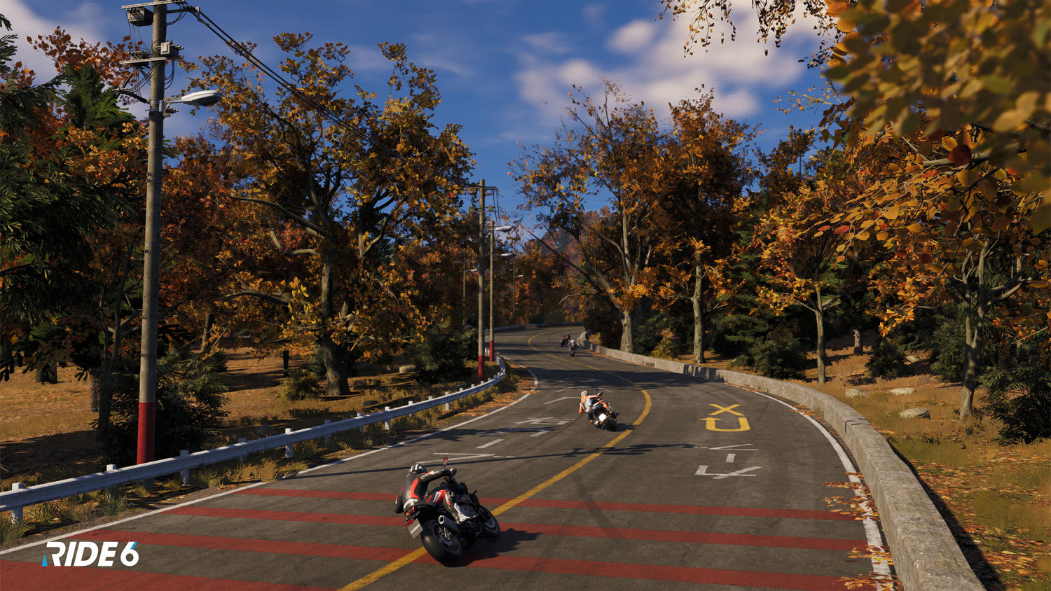 Motorradfahrer fahren auf einer malerischen Herbststraße mit bunten Bäumen und blauem Himmel.