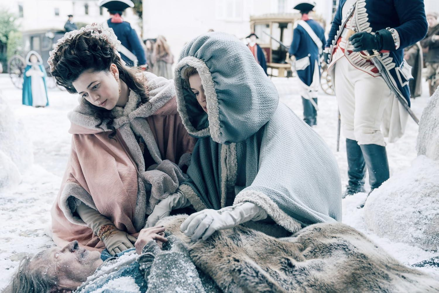 Zwei Frauen in Winterkleidung untersuchen einen Mann im Schnee. Soldaten im Hintergrund.
