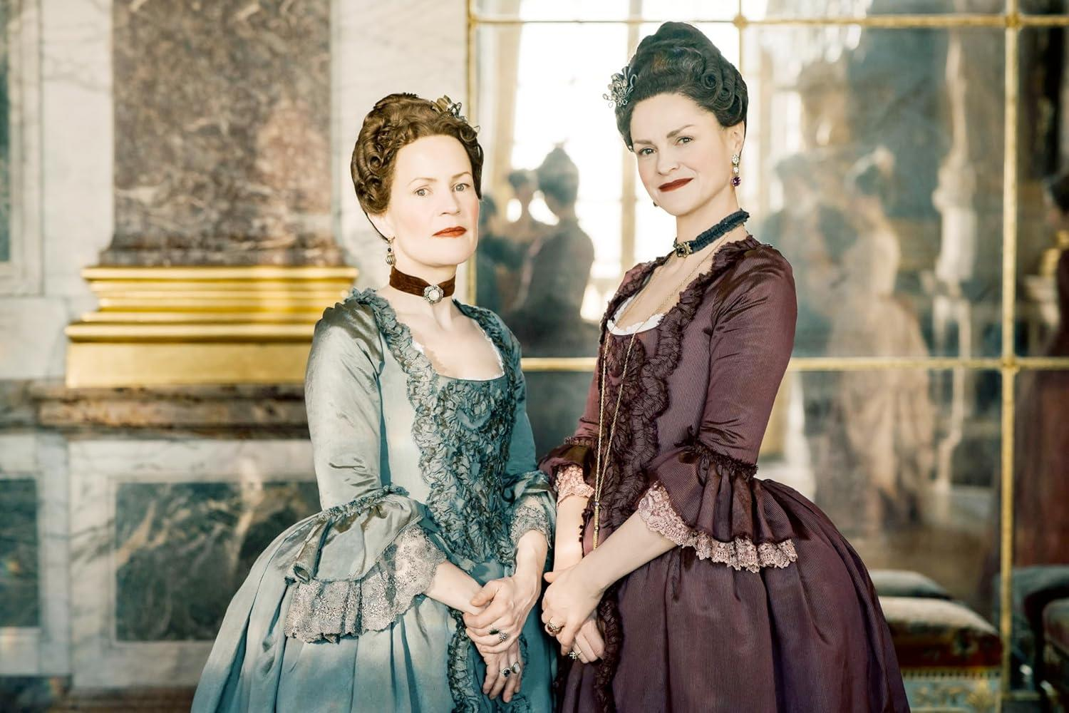 Zwei Frauen in historischen Kleidern stehen vor einem Spiegel.