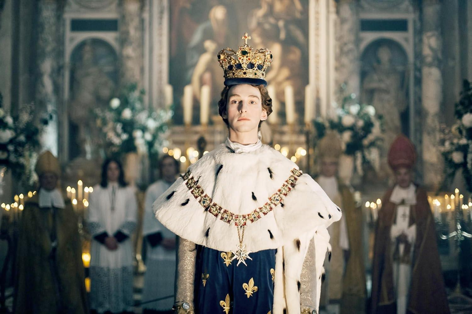 Ein junger Mann in königlicher Robe und Krone steht in einer Kirche.