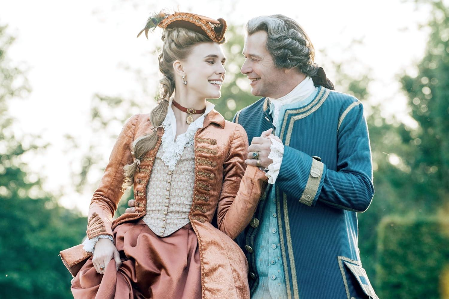 Ein Mann und eine Frau in historischer Kleidung halten Händchen und lächeln sich an.