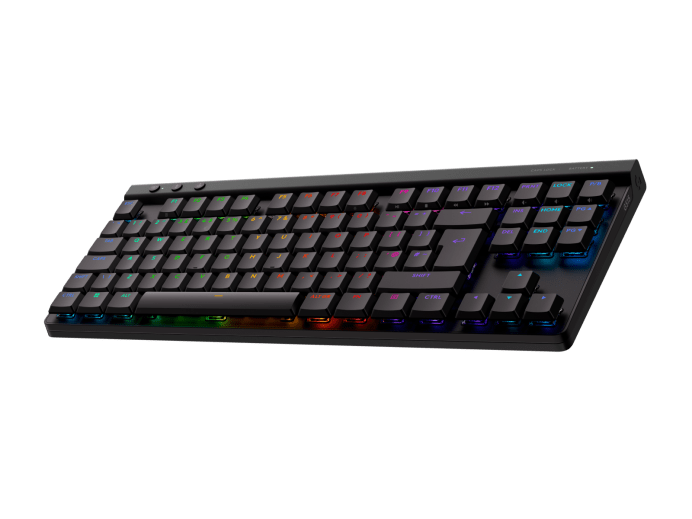 Fekete billentyűzet RGB világítással, közelről, zöld háttéren.
