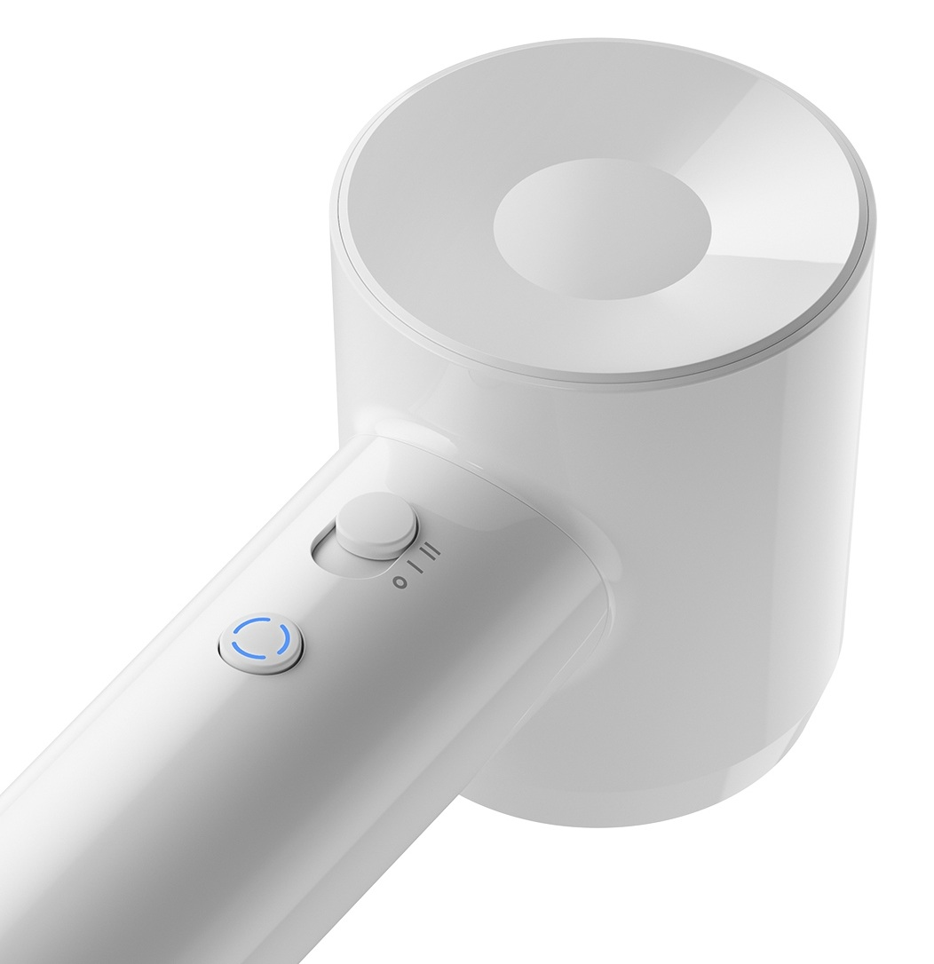 Białe, cylindryczne urządzenie z rączką i przyciskami. Przełącznik znajduje się pośrodku.