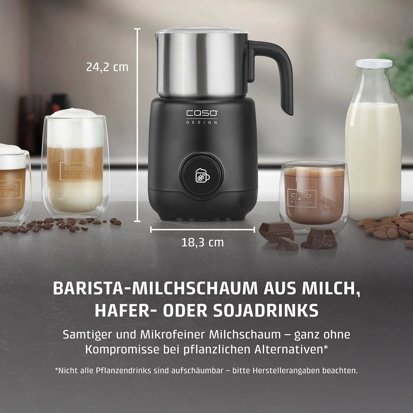 Ein schwarzer Milchaufschäumer mit Edelstahl-Deckel, daneben Gläser mit Kaffee und Milch.