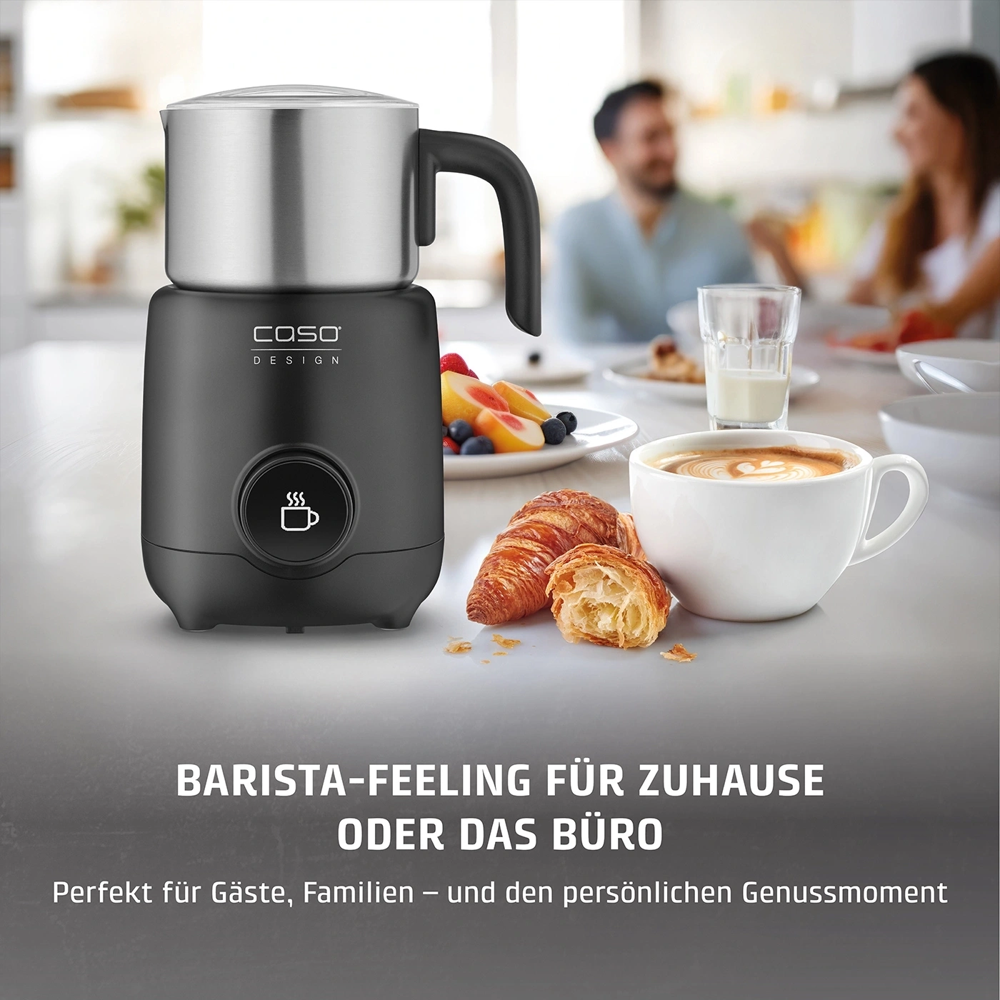 Ein schwarzer Milchaufschäumer steht neben Croissants und Kaffee.