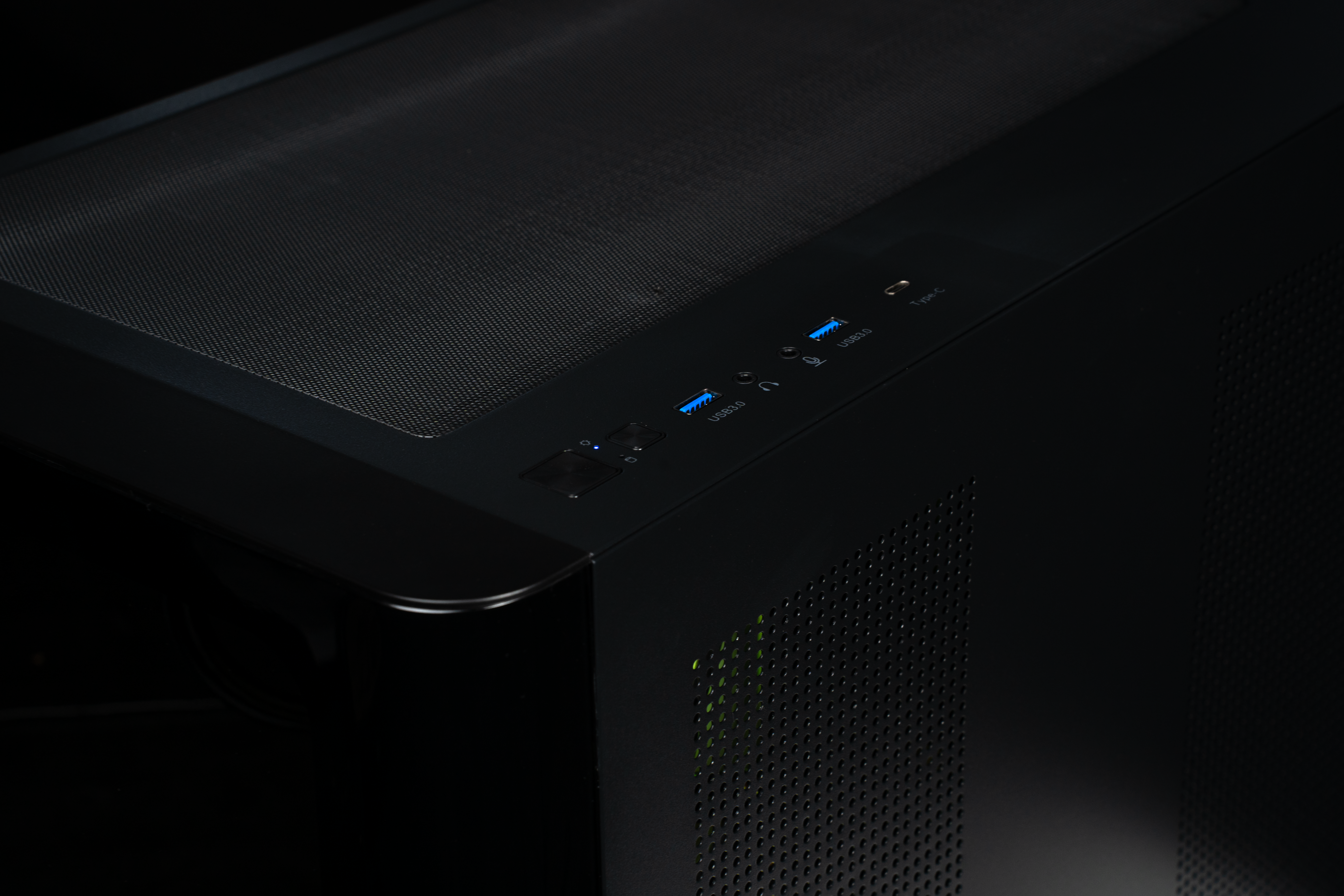 Fekete számítógépház kék USB 3.0 és USB-C portokkal a tetején.