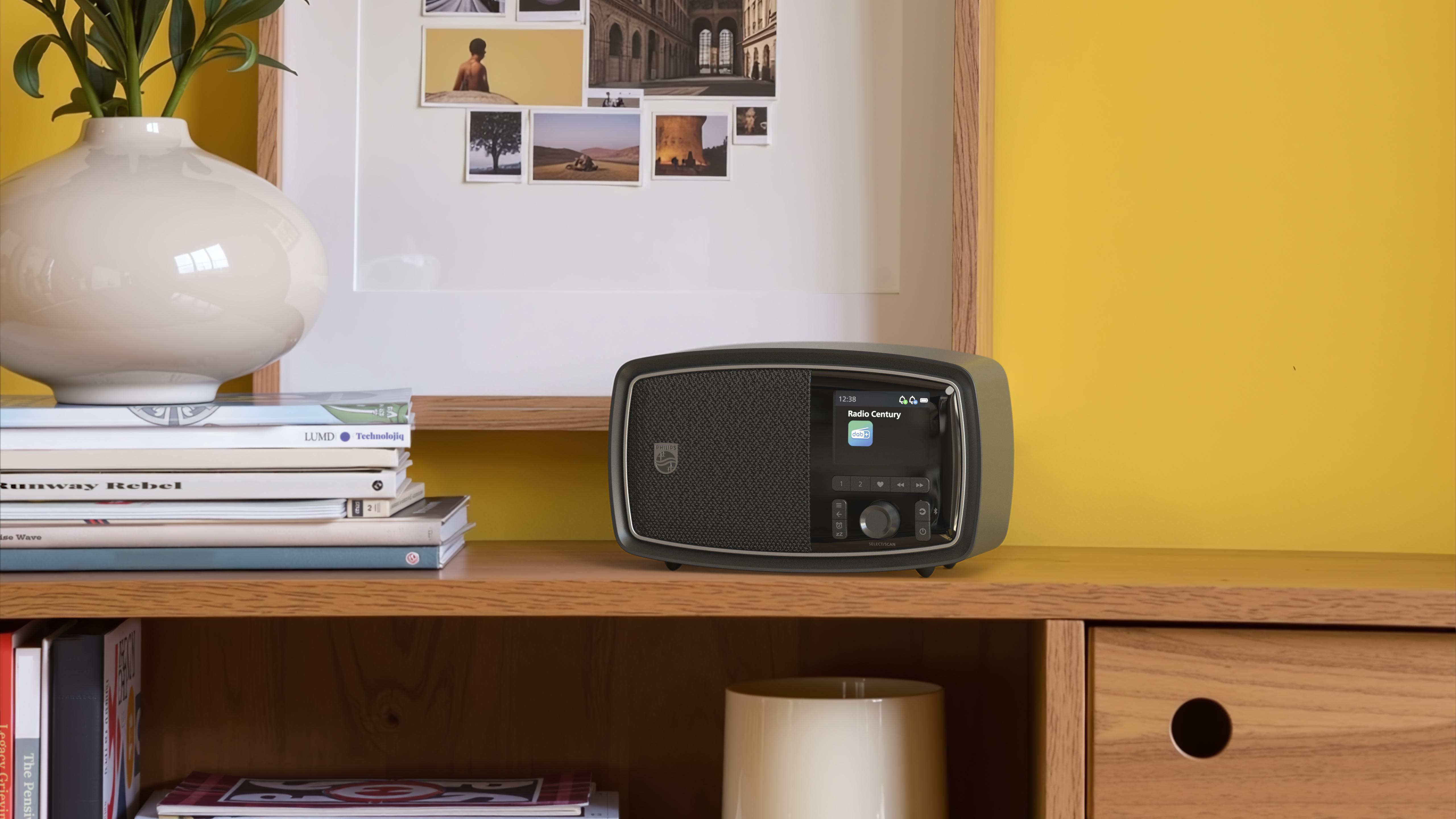 Ein Retro-Radio steht auf einem Bücherregal vor einer gelben Wand.